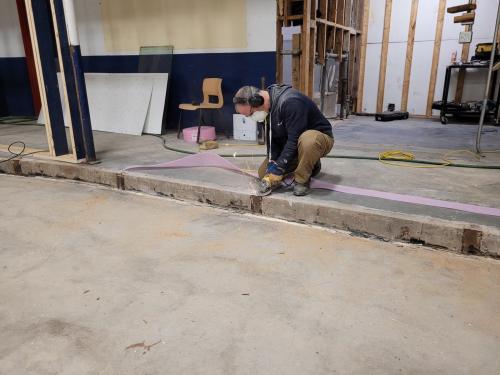 Grinding railroad ties from old hockey boards down to new court surface